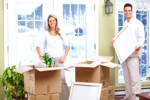 Local removals team handling furniture in a Ruislip residential street